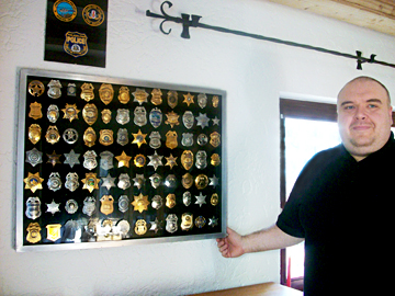 Museumsleiter Dr. h.c. Christian Harbauer vor einem der Schaukästen mit den US-Polizeiabzeichen